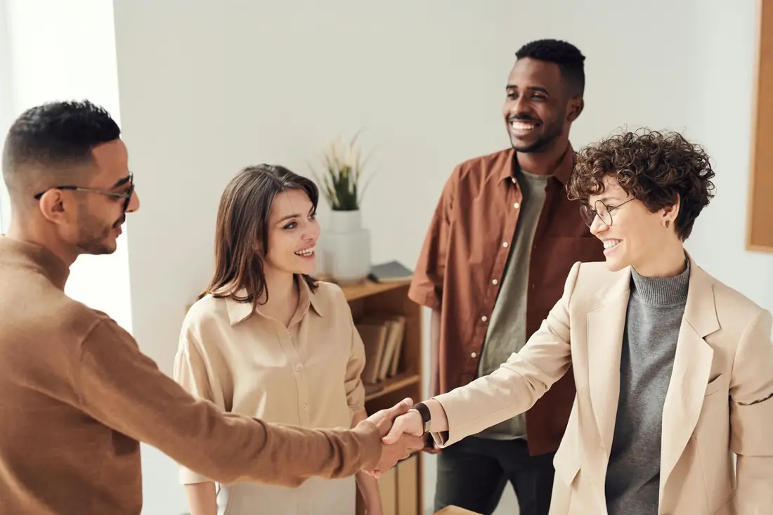 Ein Team begrüßt sich gut gelaunt im Büro